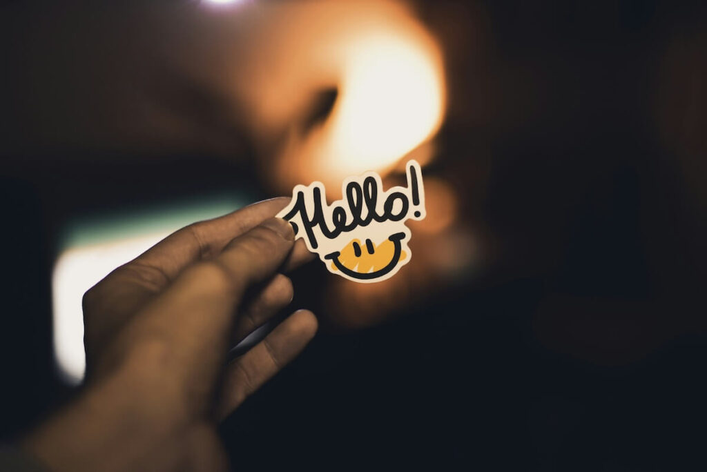 person holding "hello" sticker
