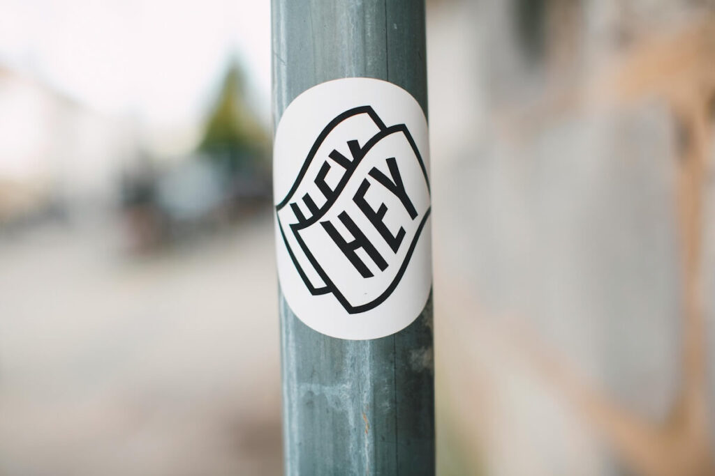 sticker that says "hey hey" taped on post