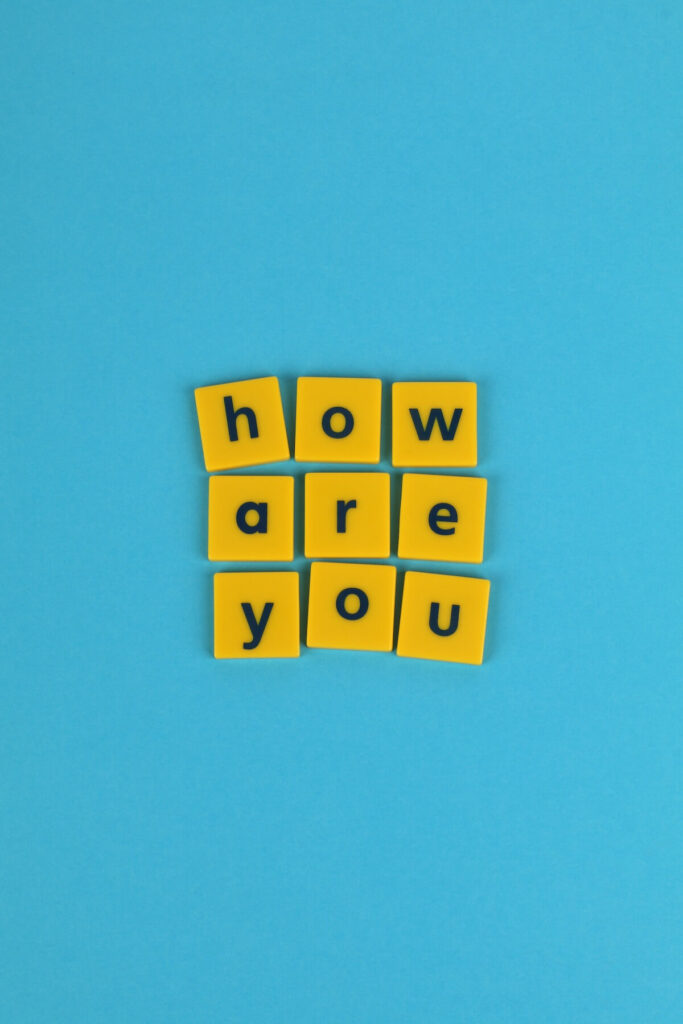 Bright yellow letter tiles on a blue background spelling 'how are you'