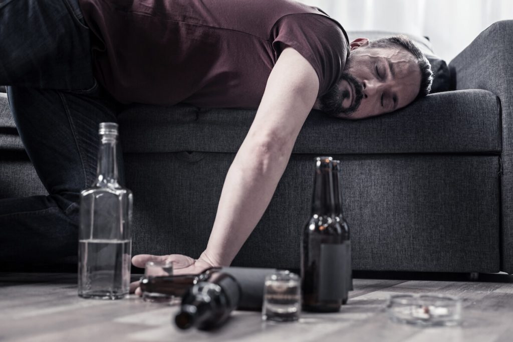 Drunk man sleeping to demonstrate "Boire comme un trou"