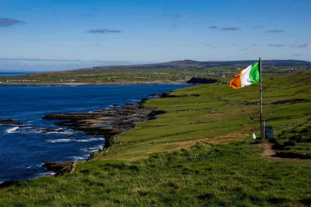 Irish flag at the hiking trail leading from Doolin to the Cliffs of Moher, County Clare, Ireland