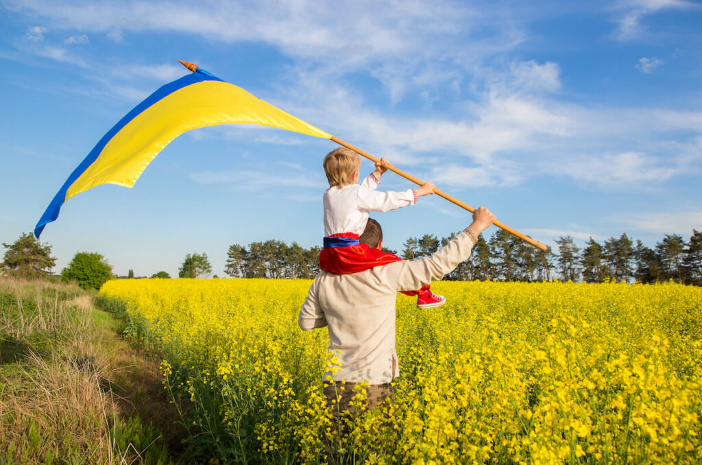 Man and son carrying Ukrainian flag
