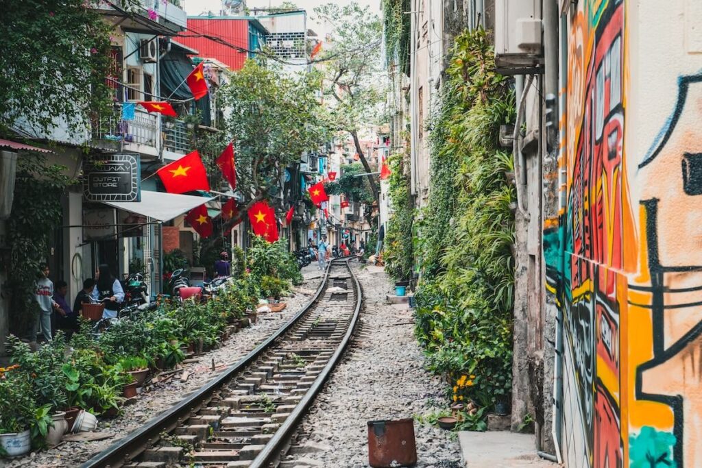 railway in Hanoi, with restaurants, cafes, and Vietnamese flags on the sides