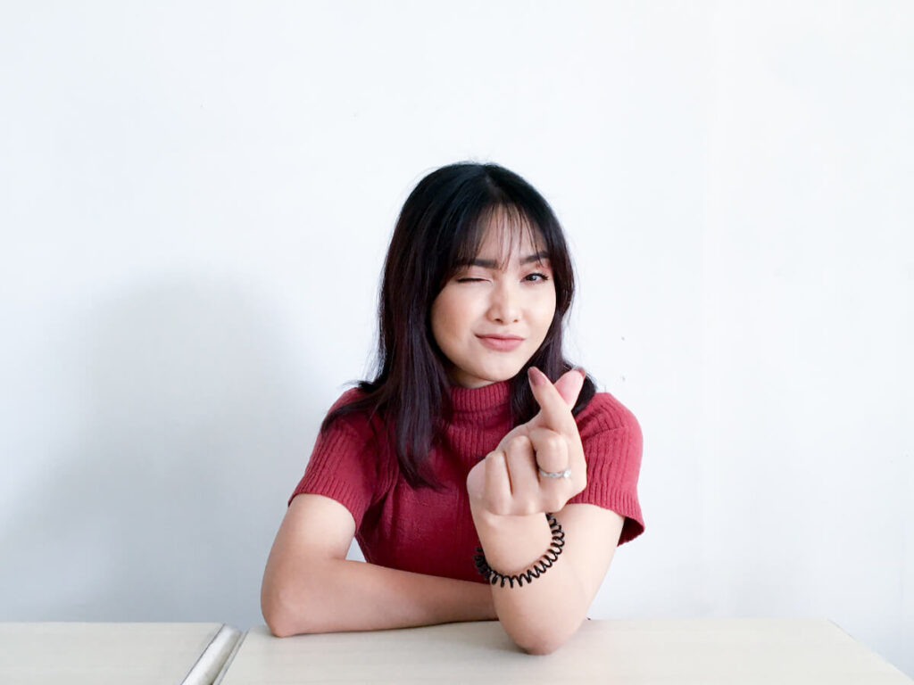 Woman smiling with finger heart