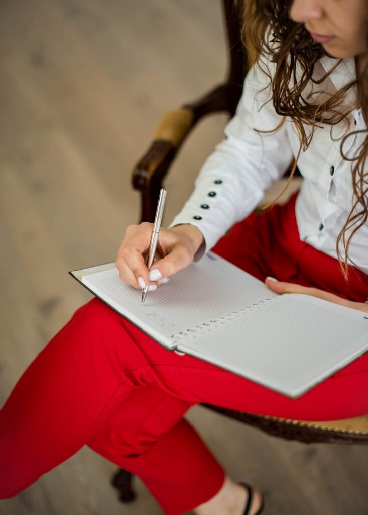 woman writing with pen on paper