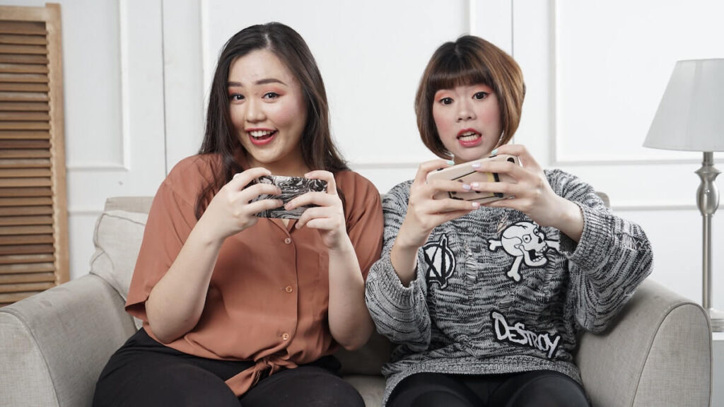 women playing video games on phone