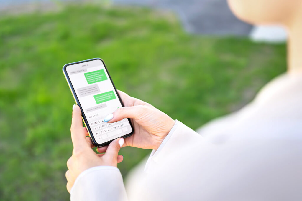 Woman texting on phone outdoors