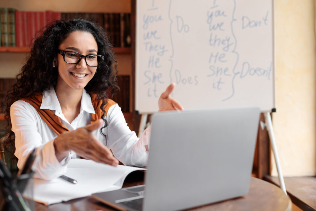 female English tutor smiling, teaching online