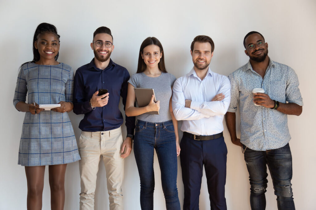 Smiling mixed race group of young employees looking at camera