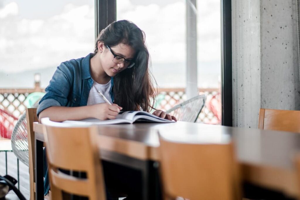 female student studying with book and notebook