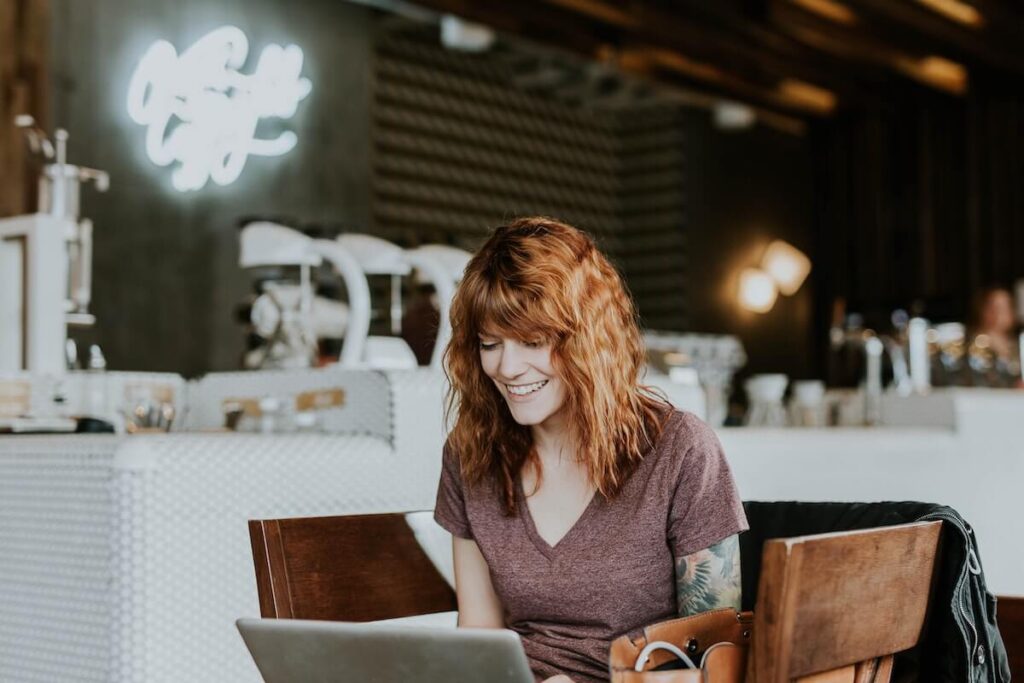 Woman in a cafe talking to person in laptop