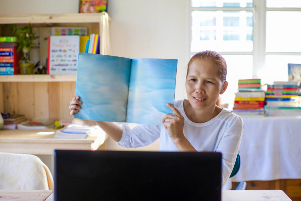 Female teacher showing story book