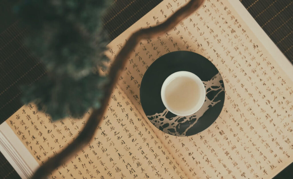 A Chinese book with cup of tea on top
