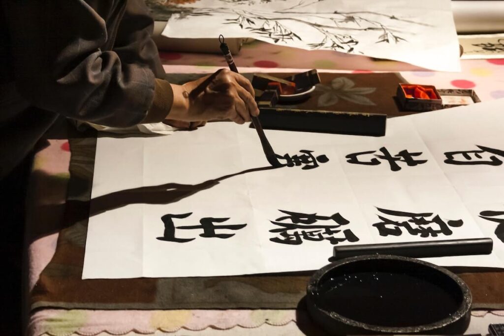 Old man painting Chinese characters on paper rice