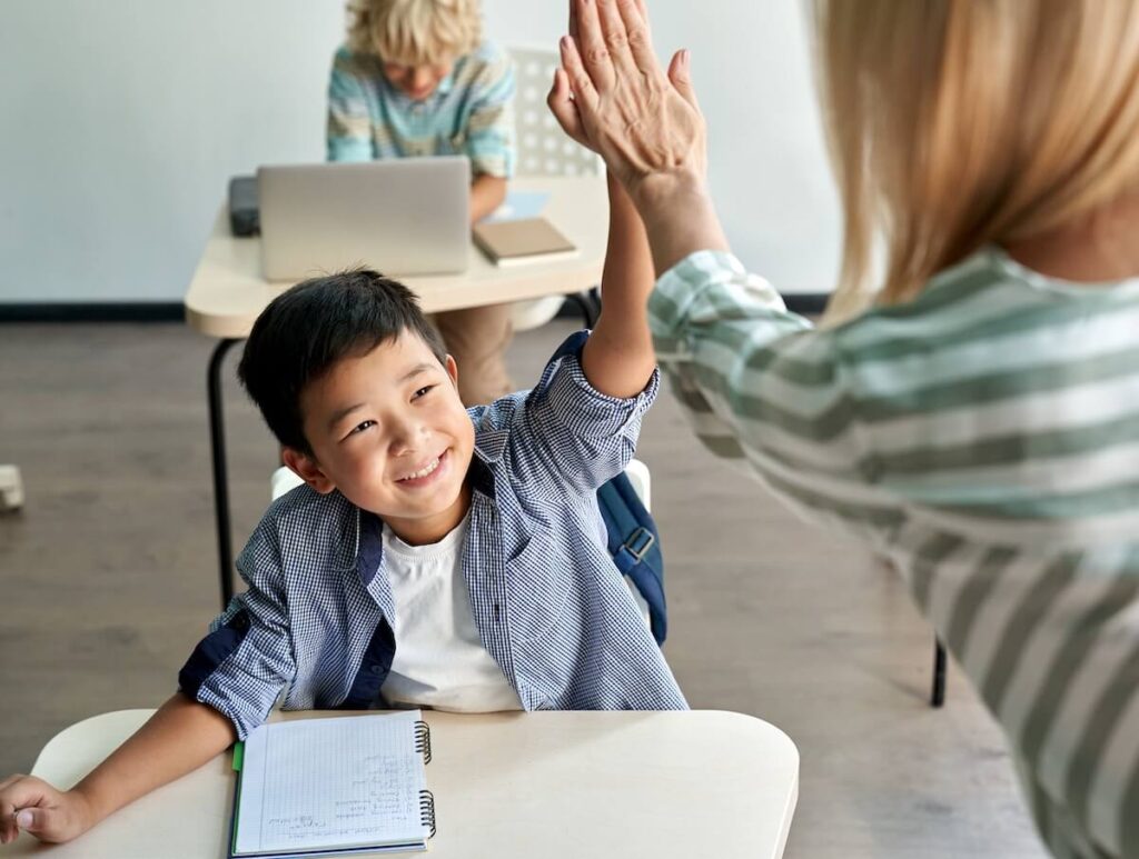 teacher encouraging and giving a high-five to a student