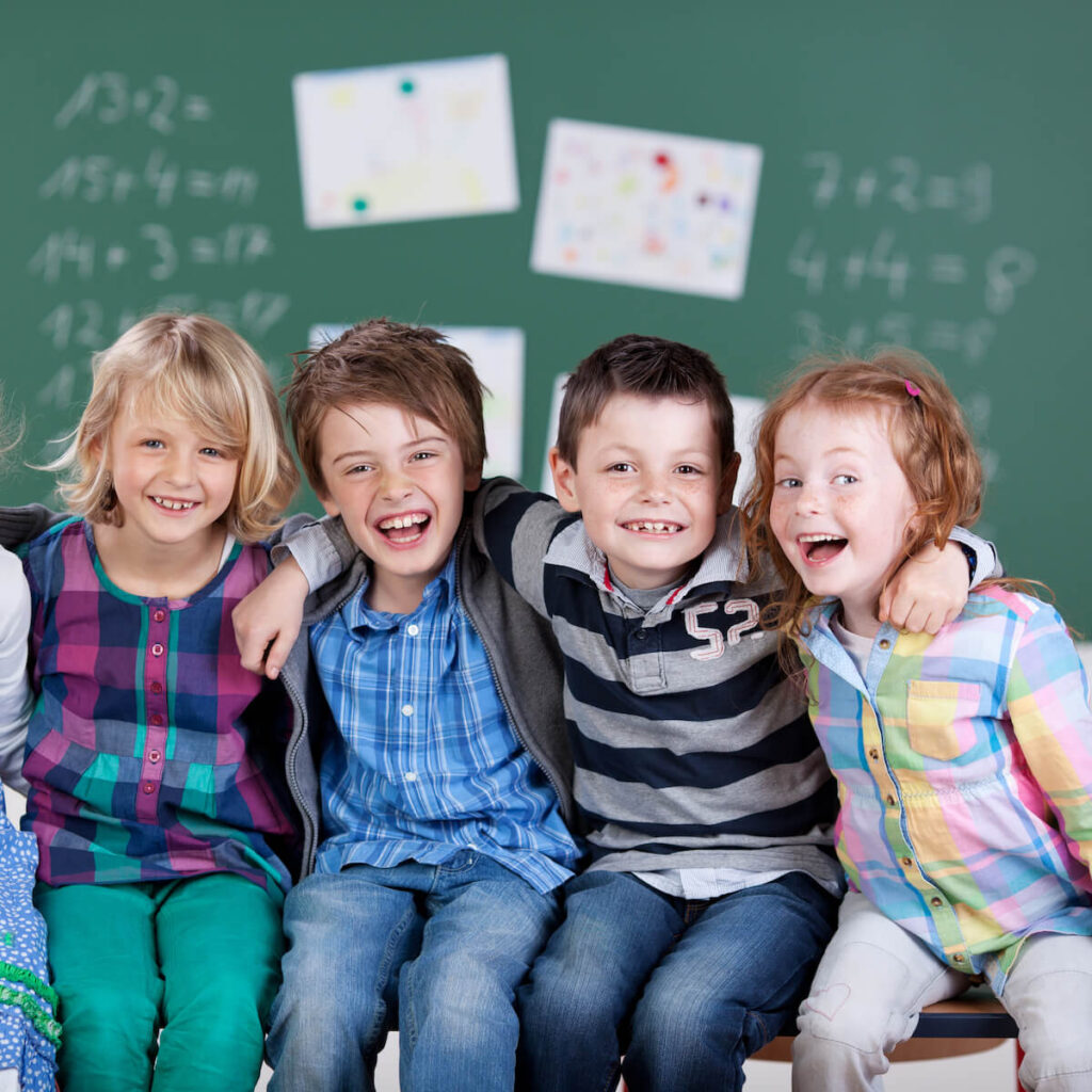 Portrait of happy little students at school