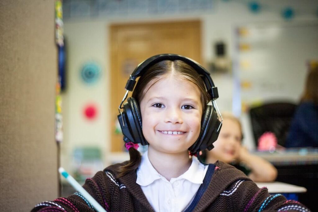 girl wearing headphones, listening to music. Music is one of the best ways on how to teach Spanish to beginners.