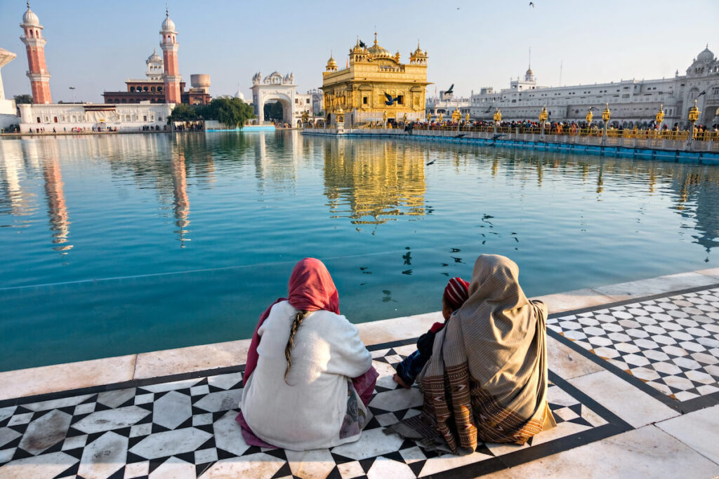 two men looking at the Golden Temple in Amritsar, Punjab, India