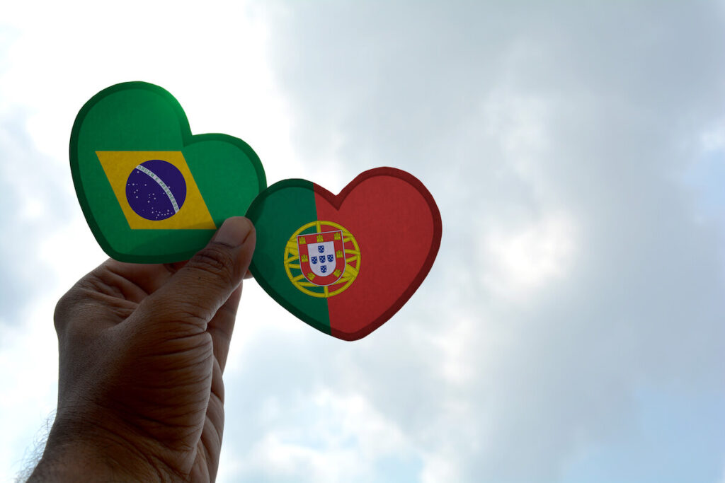 Hand holds a heart Shape Brazil and Portugal flag