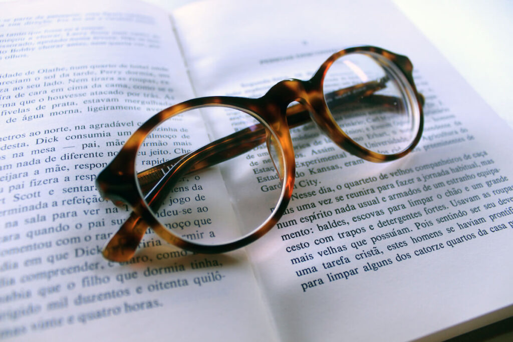 Reading glasses on a open book written in Brazilian Portuguese