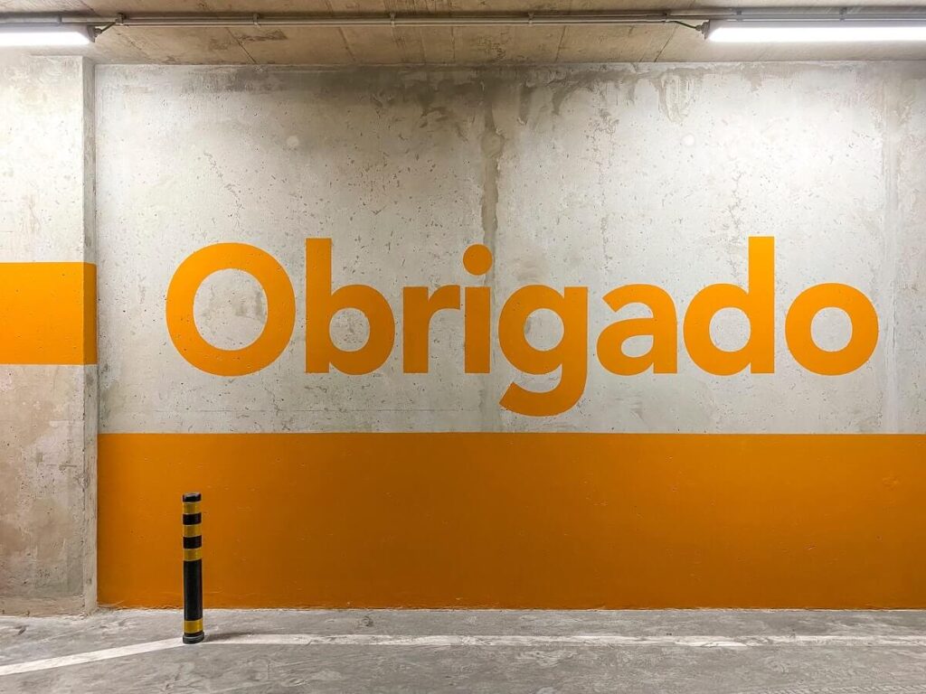 orange obrigado painted on garage wall