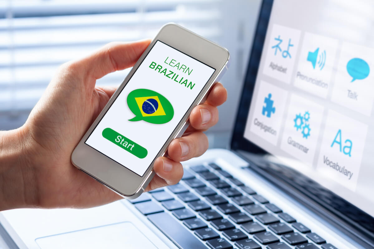 Learn Brazilian Portuguese language online concept with a person showing e learning app on mobile phone