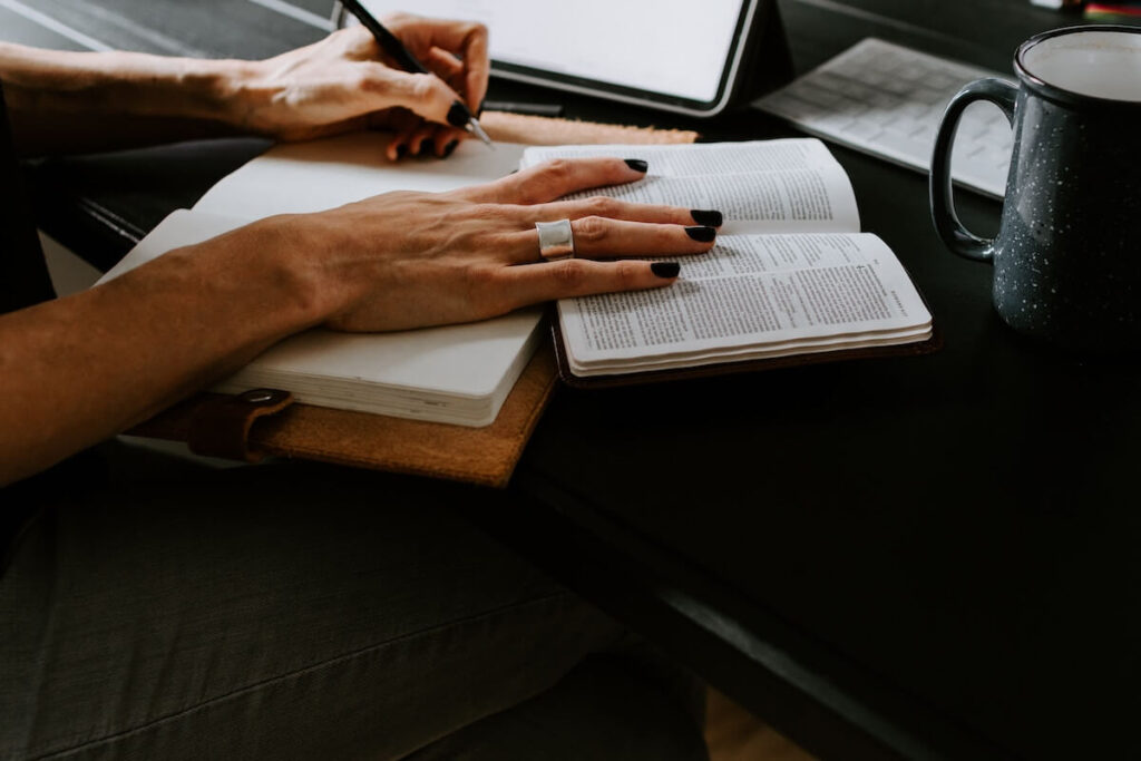 woman read book and writes on notebook