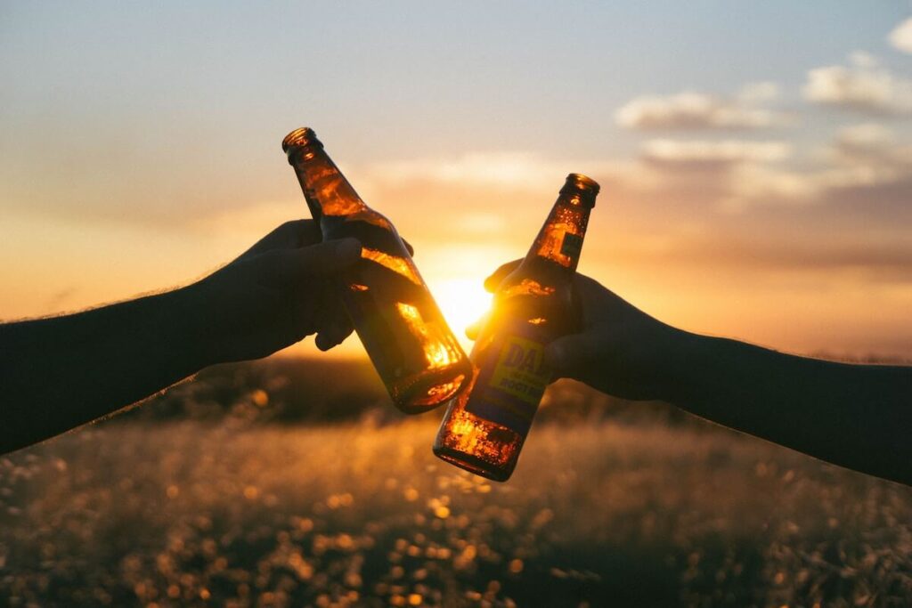 toasting with beer at sunset