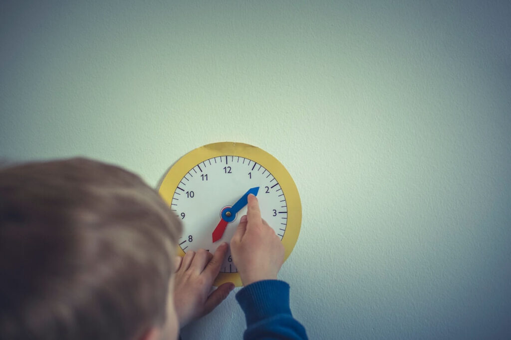 boy reading time with paper clock