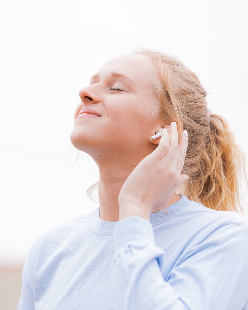 woman listens to music with earphones