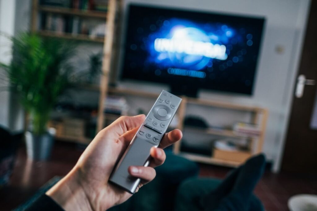 person using remote to play movie