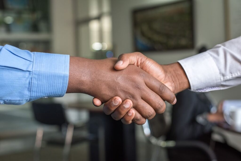 two men shaking hands business setting