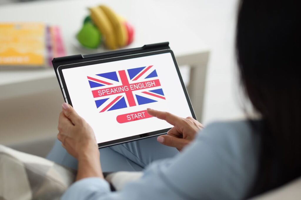 woman pressing on tablet screen to start learning English language online