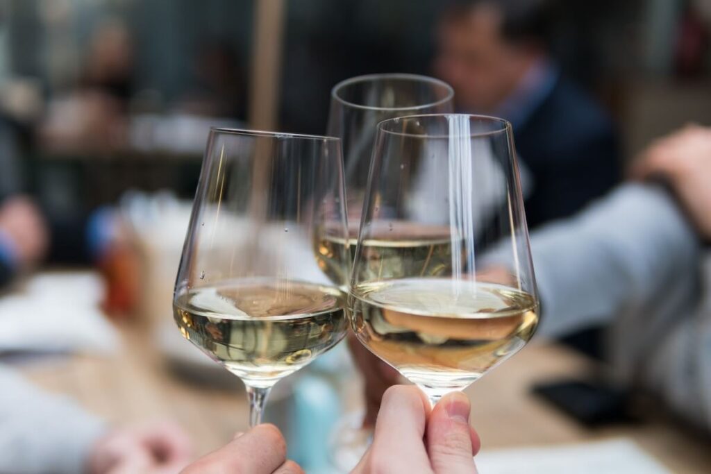 three people toast with white wine