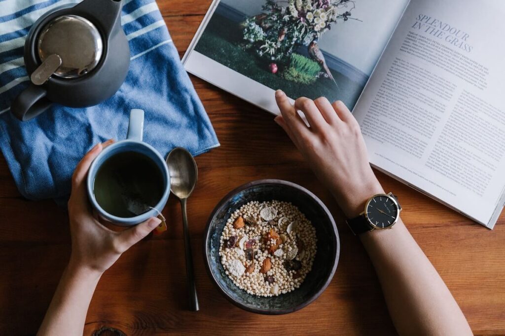 woman reads book while having breakfast