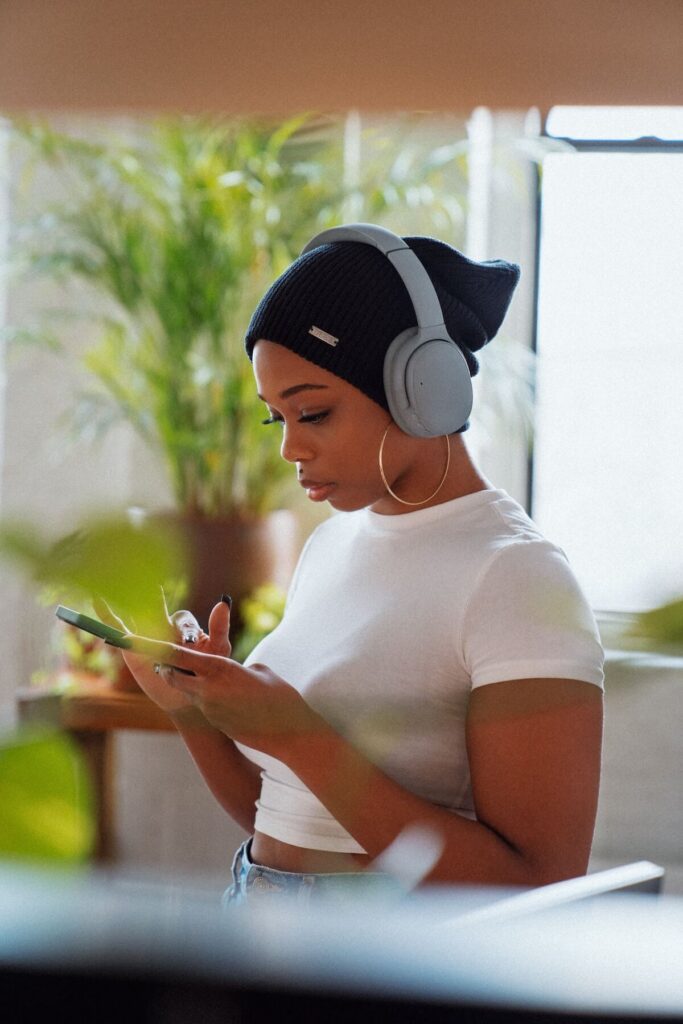 woman with headphones on pays attention to phone