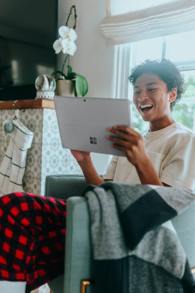 young man laughing at tablet