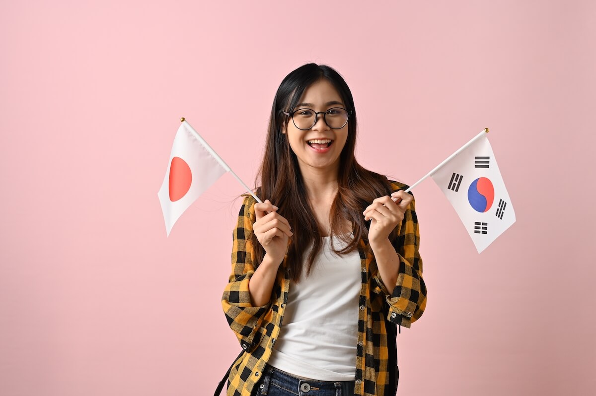 student holding Japanese and Korean flags