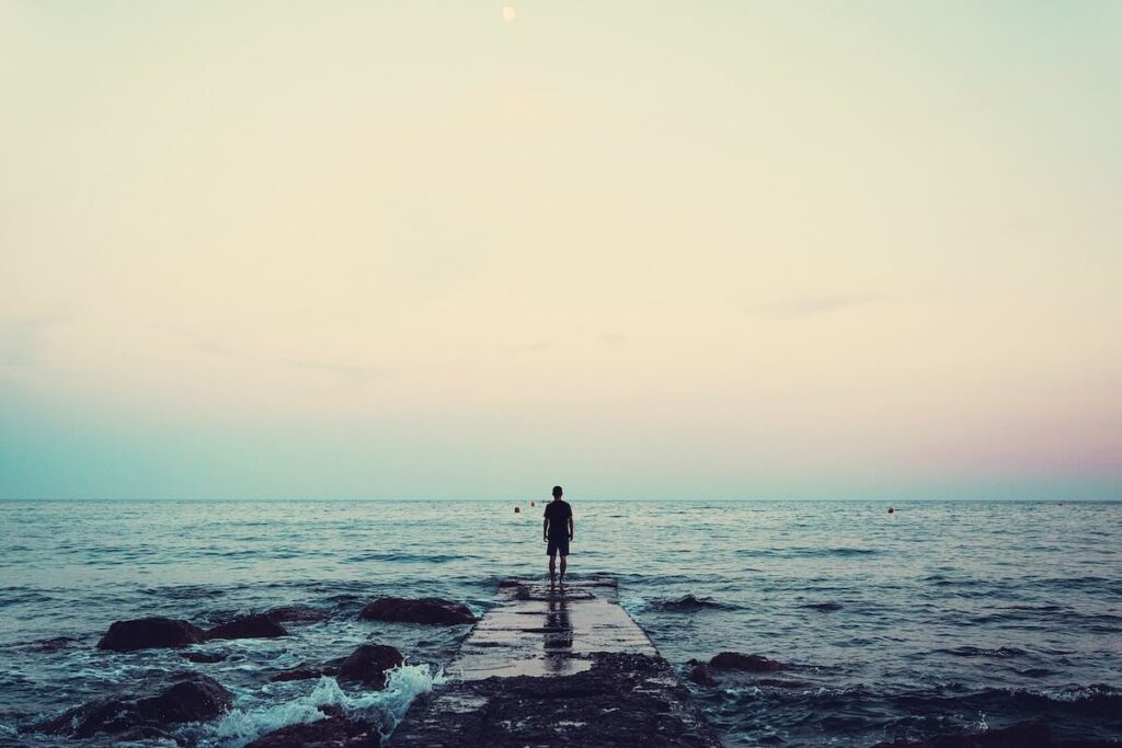 man faces sea at dusk