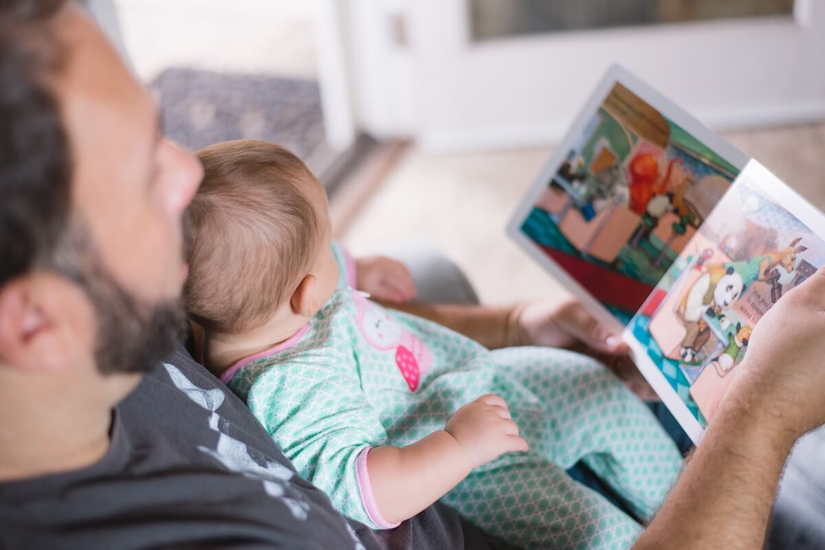 man reading book to toddler