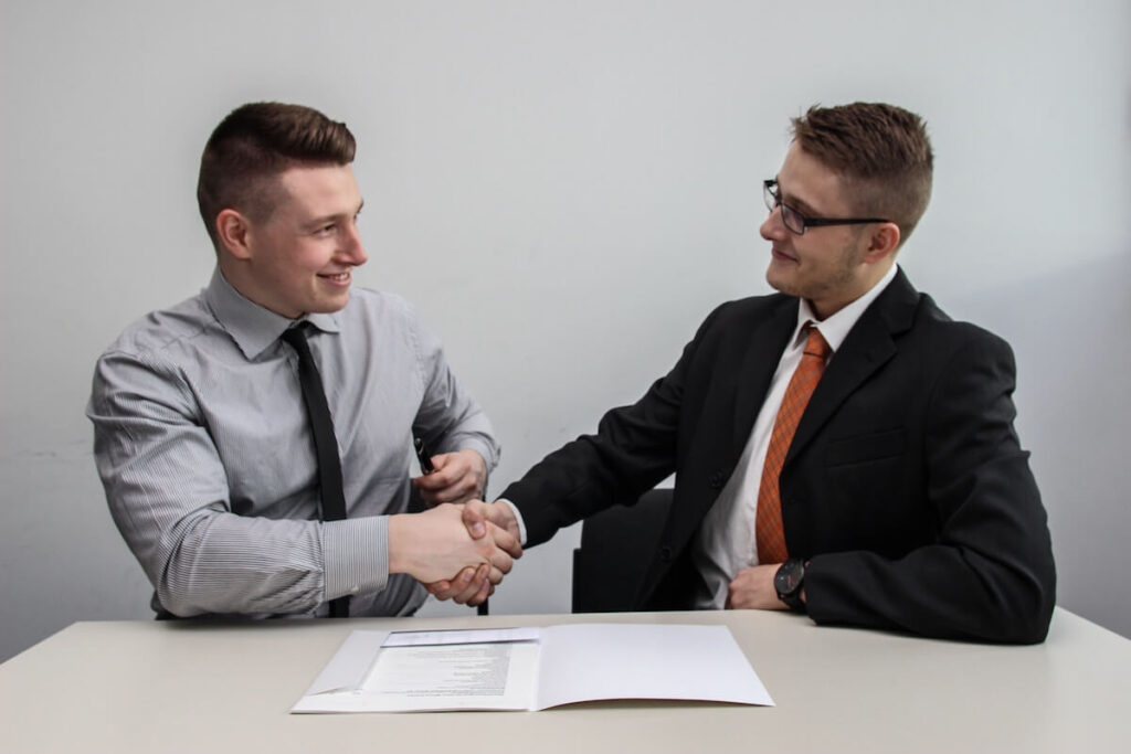 two men shake hands in business setting