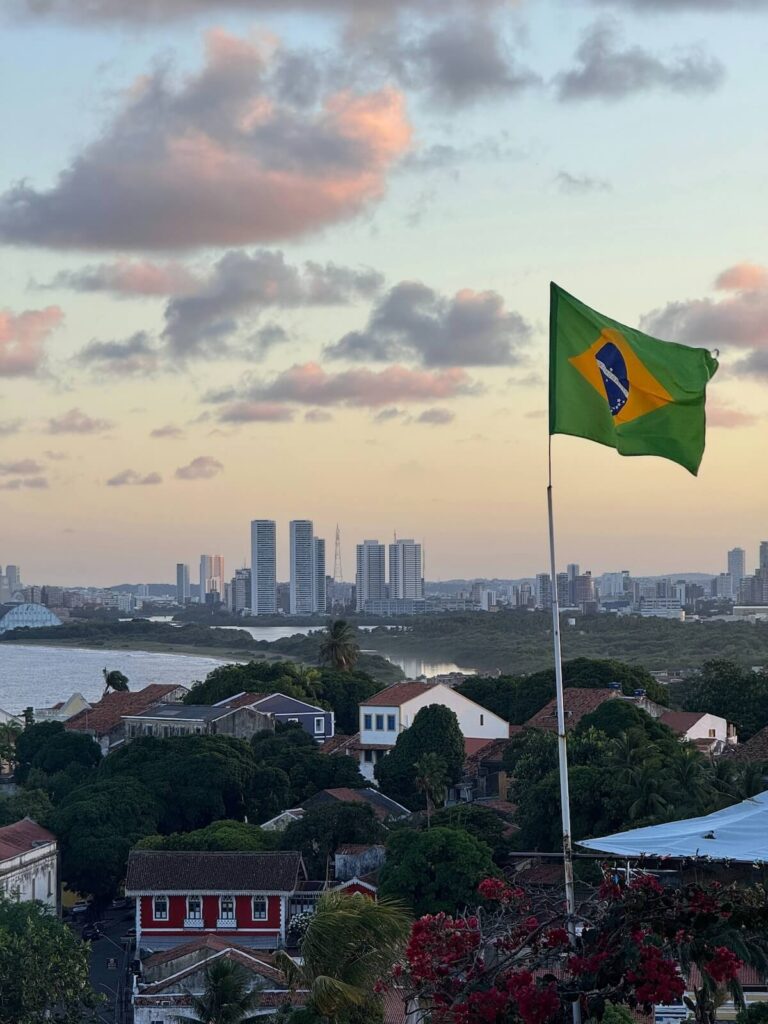 Brazil flag waving over Olinda cityscape