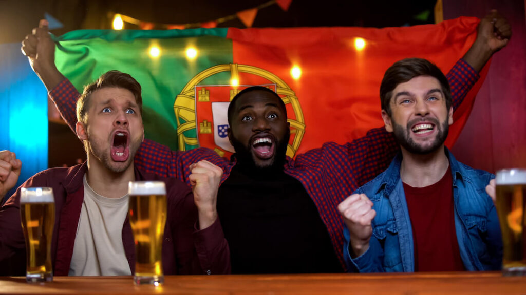 Portuguese men cheering on sports match