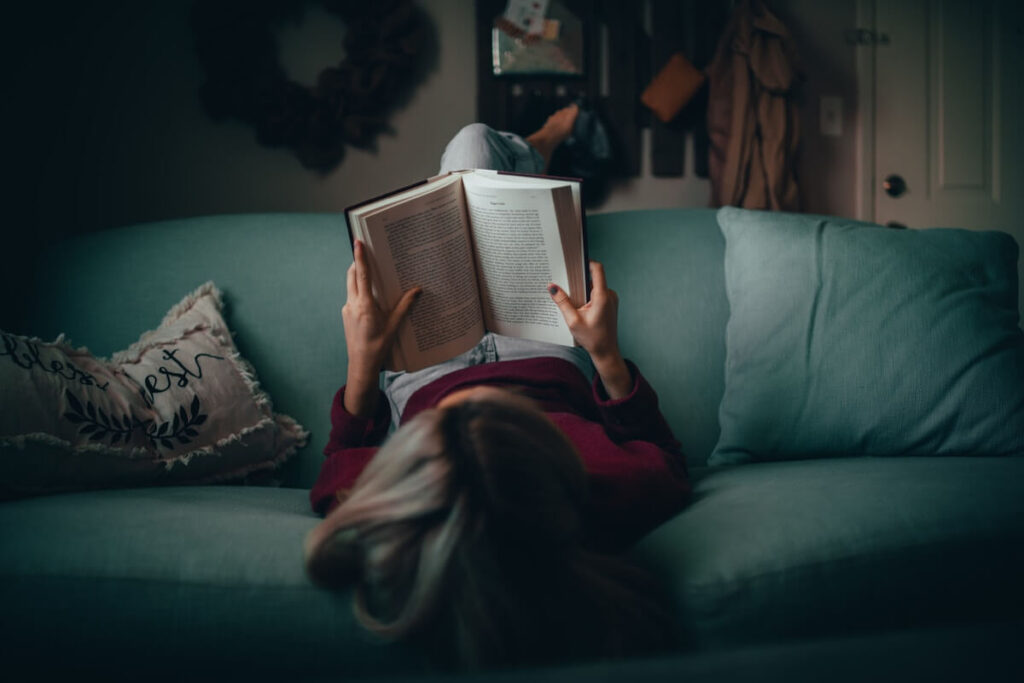 woman reading upside down on couch