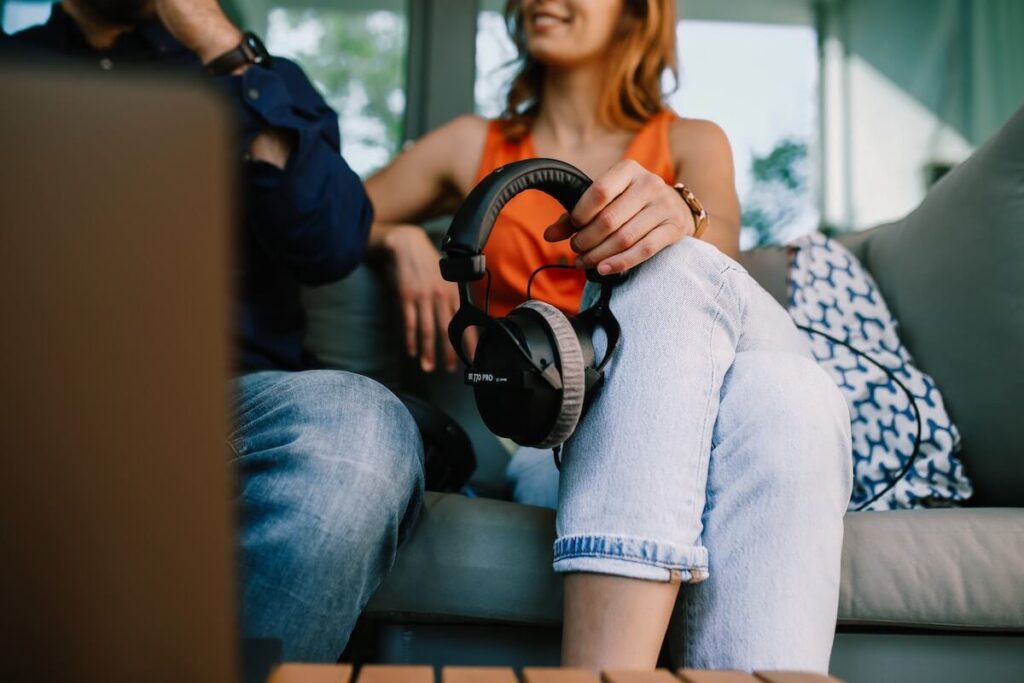 woman holding headphones on couch