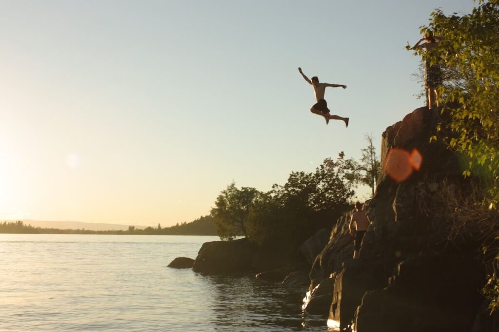 man diving into lake in sunny afternoon