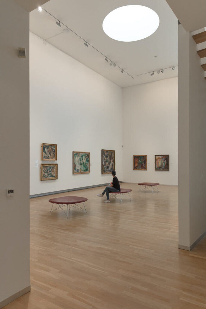 man looking at museum paintings