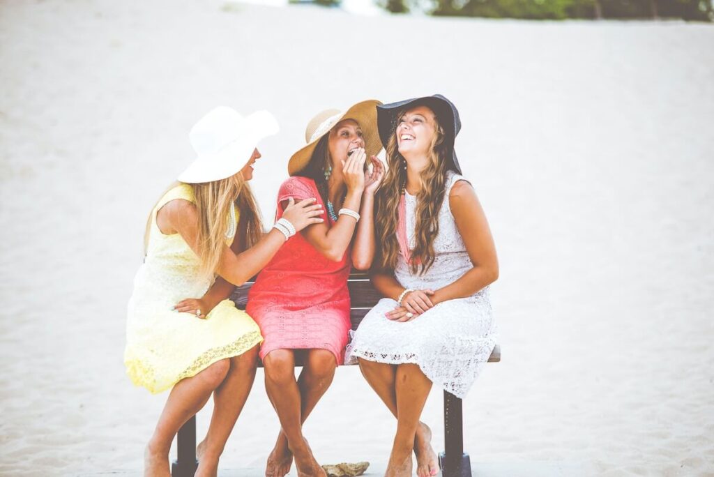 three women gossiping by body of water