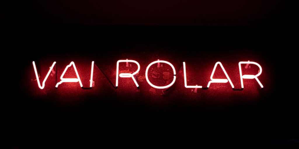 Neon sign at the entrance of a restaurant (Cá Já) in Recife where it reads "vai rolar" ("it will happen")