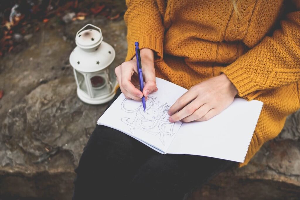 woman drawing on notebook